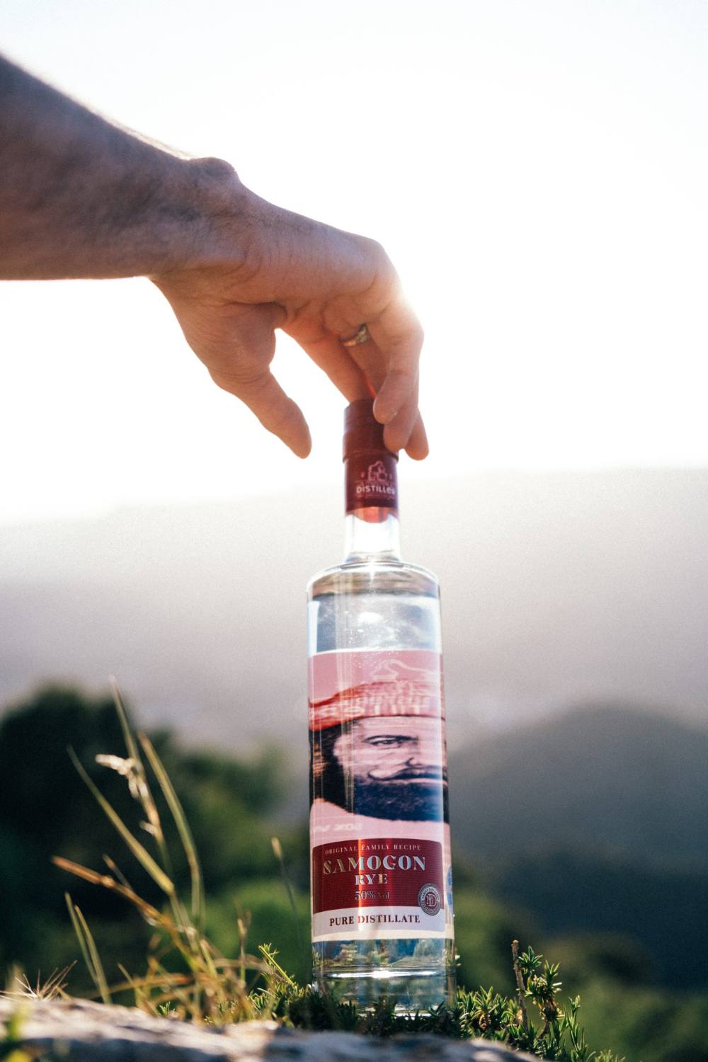 Master Distiller bottle held against a mountain sunset